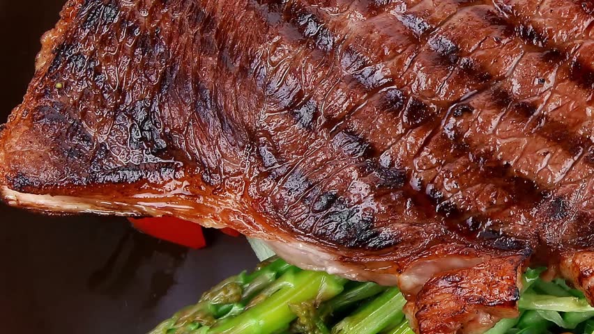 meat table : grilled beef fillet with asparagus and tomatoes served on dish slow motion  hidef