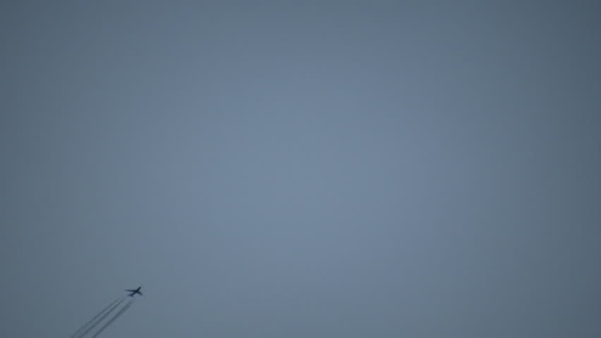 Condensation vapour trails are left behind from a passing airplane.  Also known as contrails, cirrus clouds, or wingtip vortices. (High Definition)