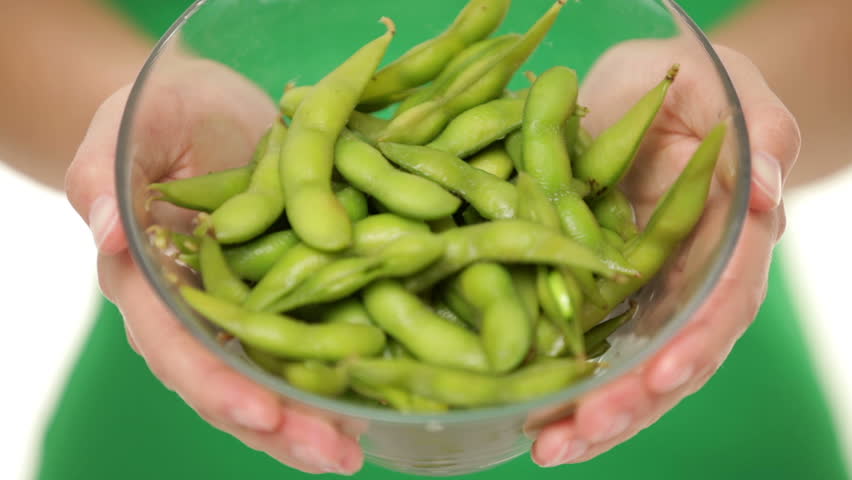 Soy beans - healthy food. Woman showing healthy green fresh edamame bean.soya beans in closeup.