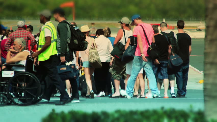 PUNTA CANA - CIRCA JAN 2013: Passengers wait in line on the tarmac at the Punta Cana airport, Dominican Republic to board an airplane circa January 2013.