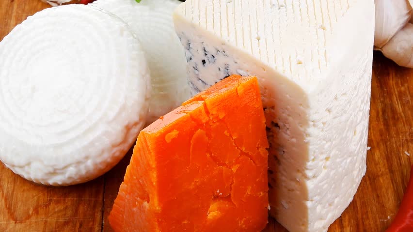 delicatessen french cheese on wooden board with hot peppers and dill hidef intro slow motion