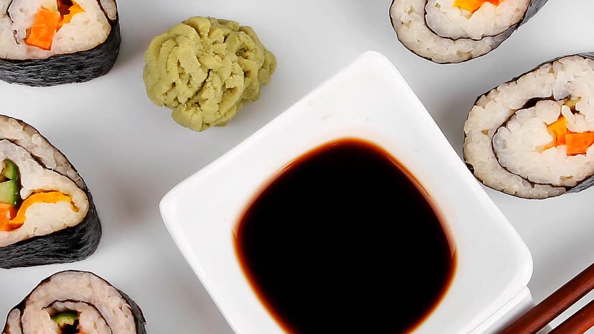 Maki Sushi : Maki Rolls and California rolls made of fresh raw Salmon(sake) Tuna(maguro) and Eel(unagi) . on white dish with sticks hidef slow motion intro