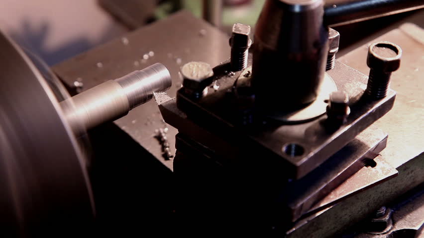 worker handles metal piece on the lathe 3