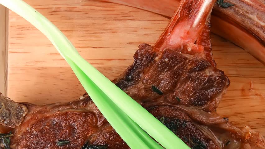 meat savory : roasted beef ribs served with green chives over black table