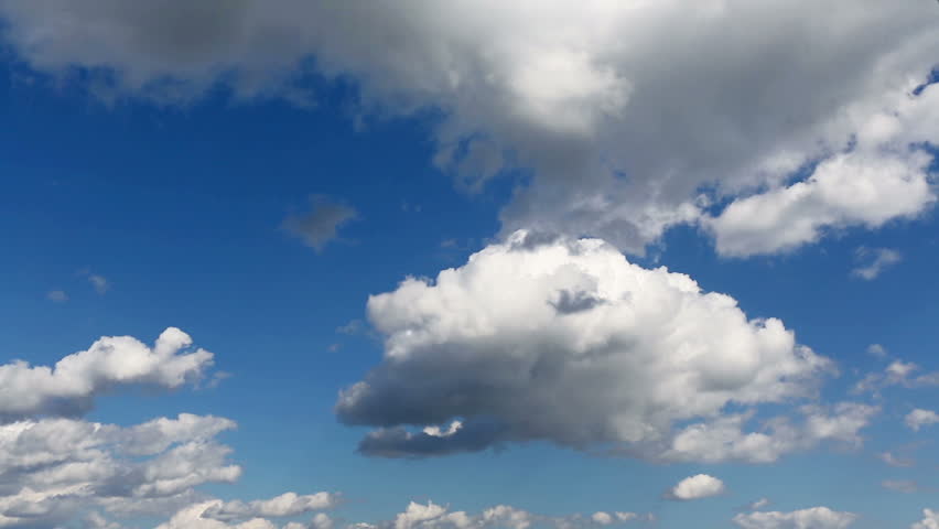 Time lapse clip of white fluffy clouds over blue sky