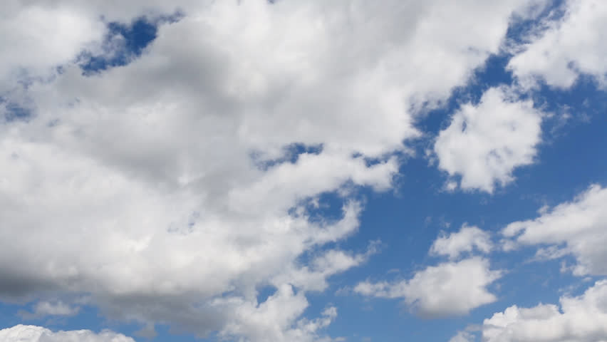 Time lapse clip of white fluffy clouds over blue sky
