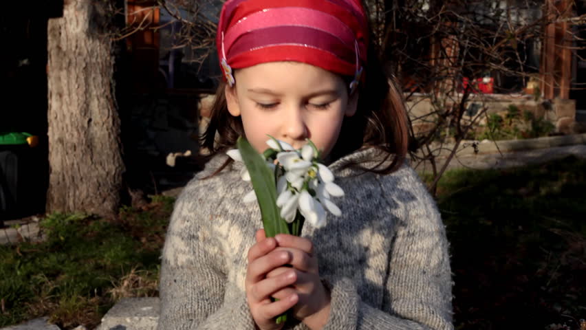 Sweet little girl arrange bouquet of spring snowdrops