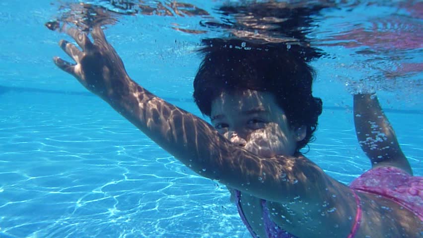 Happy active child in the swimming pool, underwater view