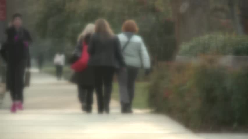 Sexy Fitness Woman jogging through business people on way to work in early morning. Slight blur so people are unidentifiable anonymous. Stock video footage High Definition :30 second clip