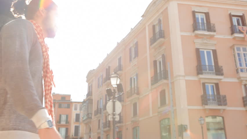 Young couples encounter, hugging and turning in a city street while on vacation.