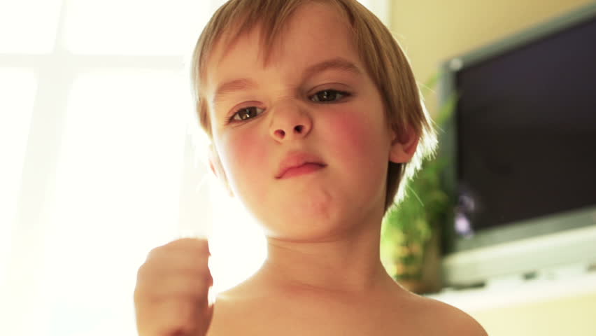 Young boy making faces in slow motion with flare 