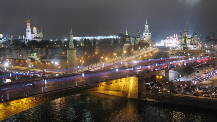 Night traffic on bridge across the river . Timelapse