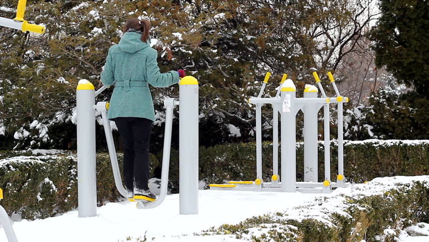 Young lady doing outdoor fitness in the park during a cold winter day
