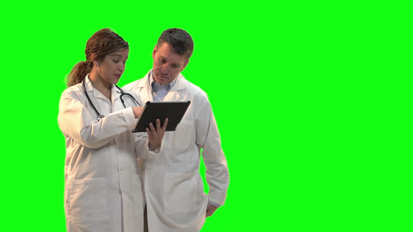 Female doctor explaining about patient with another doctor showing chart on clipboard. Shot in front of green screen.