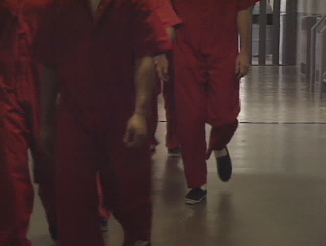 A group of prisoners in orange jump suits. 