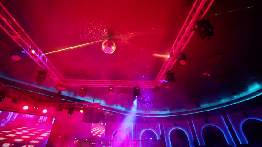 Light equipment run in night club with smoke at dance floor near bar, shown in motion