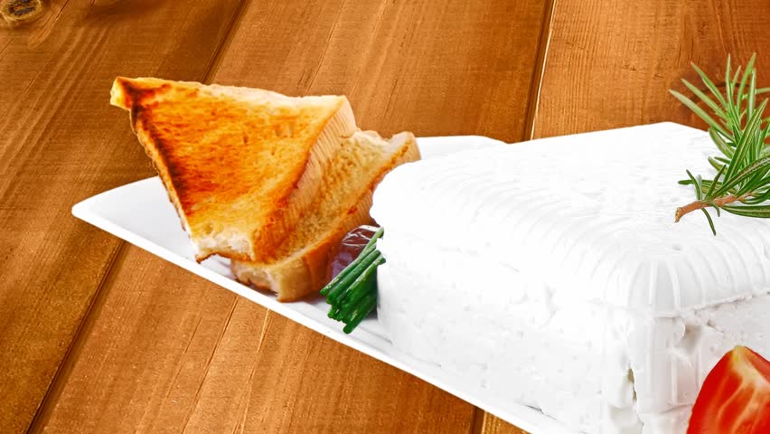 of soft feta cube and bread toast on plate