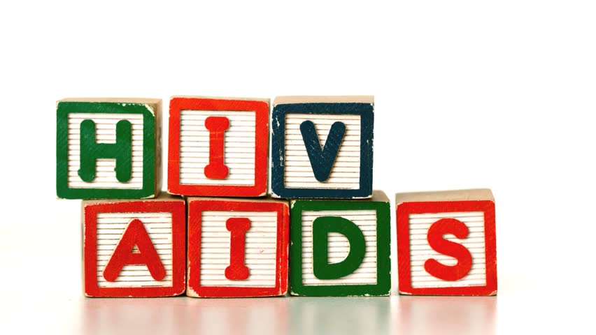 Blue condom falling on blocks spelling AIDS and HIV in slow motion