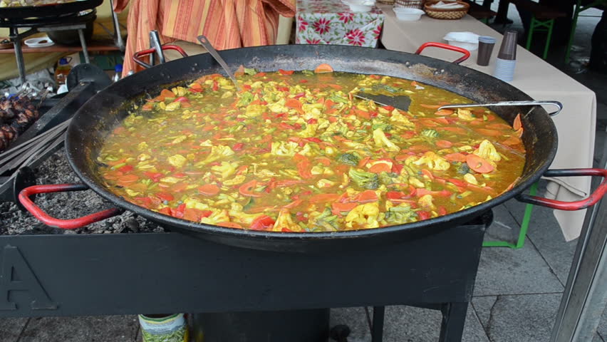 Healthy diet food vegetable stew in huge hot pan in outdoor street event.