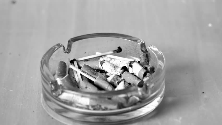 Cigarette falling in ashtray in slow motion