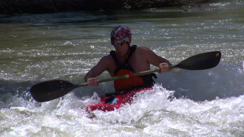 close-up on man paddling white-water kayak in slow motion