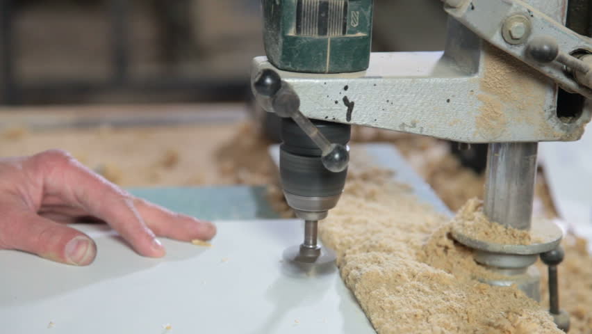 Furniture maker at work in workshop, drilling a hole