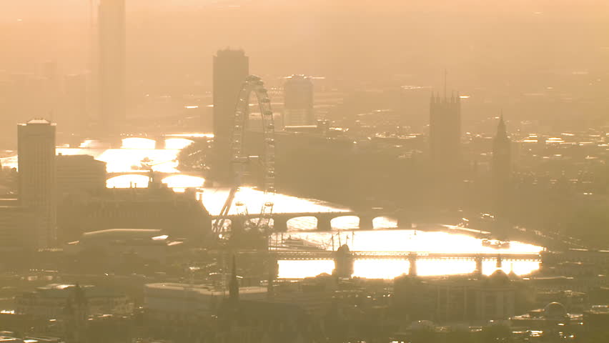 Aerial shot passing over the River Thames near Westminster on a hazy autumn morning. Many distinctive London landmarks can be seen.