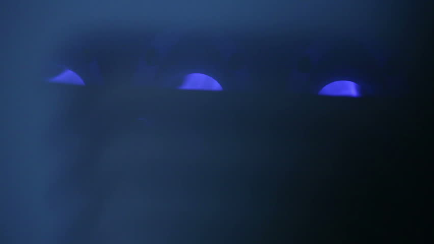 Inside a hot furnace, blue flames from the inside of a gas house heater.