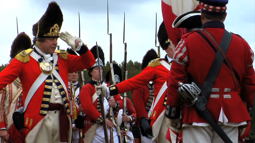 VIRGINIA - OCTOBER 2009 - large-scale, epic American Revolutionary War anniversary reenactment -- in the middle of battle.  British Redcoat Infantry Soldiers march in formation with silk flag flying.