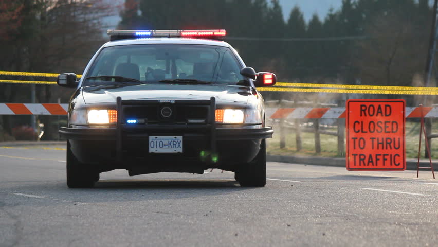 ABBOTSFORD, BRITISH COLUMBIA - MARCH 23: A patrol car is parked beside a taped off area where multiple gun shots were fired in a school playground in Abbotsford, British Columbia on March 23, 2013.  