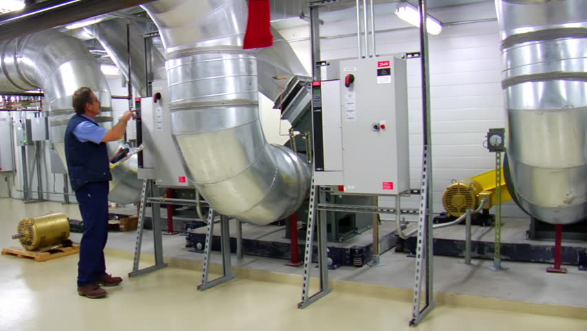 man takes readings on large air ducts