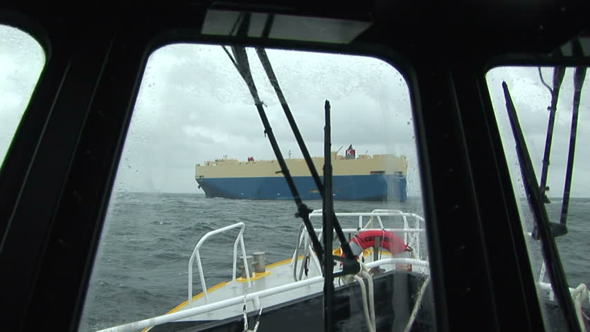 Pilot boat navigating towards cargo ship on the Columbia River, OR