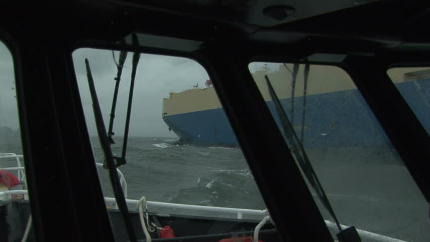 Pilot boat navigating side to side with cargo ship on the Columbia River, OR 