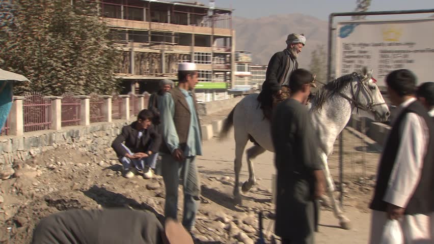Faizabad, Afghanistan - November 7, 2010:  Man on horse riding on main street in Fayzabad, Afghanistan.