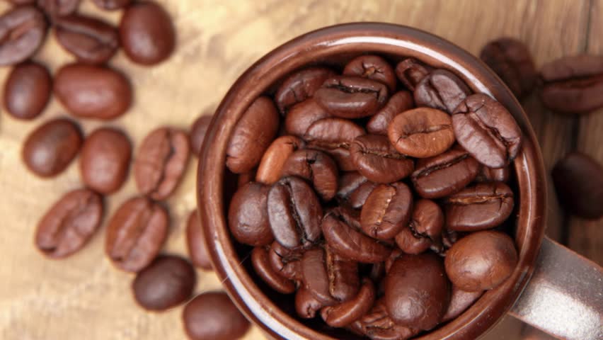 coffee beans and brown ceramic cup/Full cup of coffee beans