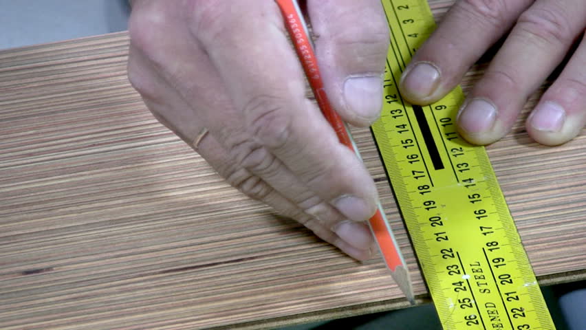 Men's hand draw a pencil line on the laminate. Men's hands are doing sawing with an electric hand-sawing