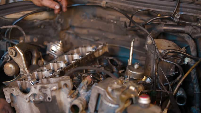 Time lapse: two repairers are dismantling car engine, close-up.