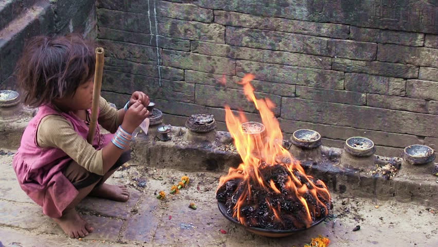 BUNGAMATI REGION, NEPAL â CIRCA OCTOBER 2011 â Little nepali girl keeps the fire during Bhairab celebration circa October 2011 in Bungamati in Nepal.
