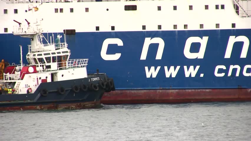 ALICANTE, SPAIN â APRIL 04: The tug "J. TORRES" is working with the general cargo vessel âTELEGHMAâ for entering in the port of Alicante; Spain; on april 04, 2013 in Alicante.
