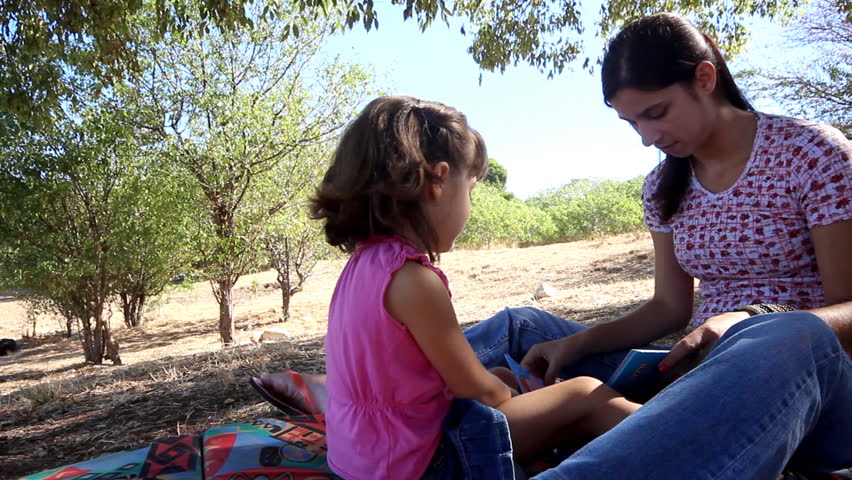 Happy readers - Mother and child reading in the nature.                  