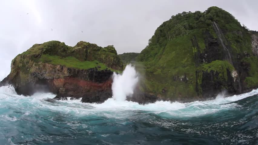Sea water shoots up a blow hole on the rugged coast of Cocos Island, Costa Rica.  This island is known for its rough seas, large numbers of sharks, and waterfalls.