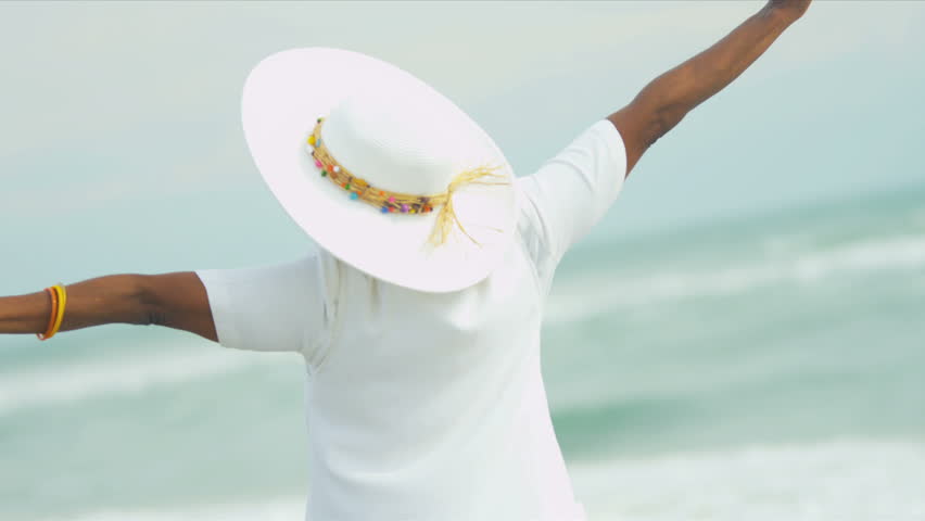 Upper body close up of elegant mature African American female reveling in her beach lifestyle beside a tropical ocean shot on RED EPIC