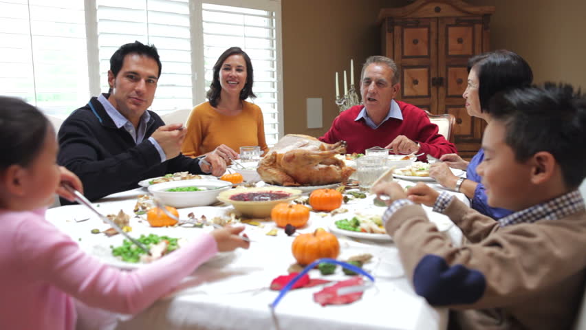 Camera tracks across table as extended family sit and enjoy thanksgiving dinner. Shot on Canon 5d Mk2 with a frame rate of 30fps