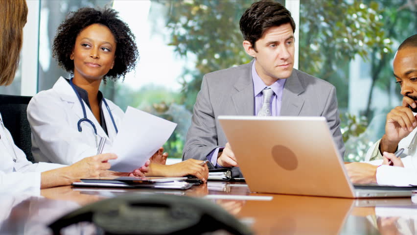 Young multi ethnic medical executives discussing future targets in boardroom of modern hospital building shot on RED EPIC