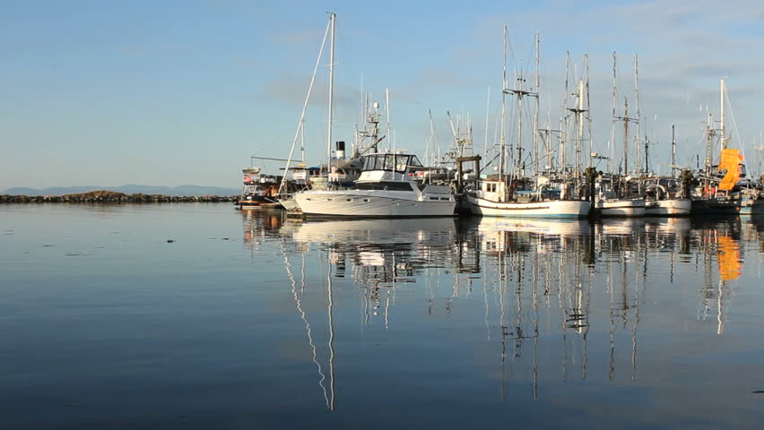 Early morning reflections in the calm water of Steveston Harbor, British Columbia, Canada where the commercial fishing fleet waits for the fishing season to open. Located near Vancouver.