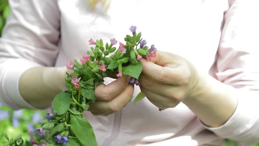 girl weaves a wreath of spring flowers