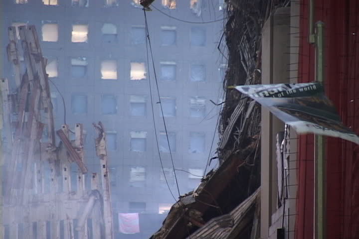 NEW YORK CITY - SEPTEMBER 28, 2001: World Trade Center rubble with smoke rising and NYC Financial flag waving from adjacent building.
