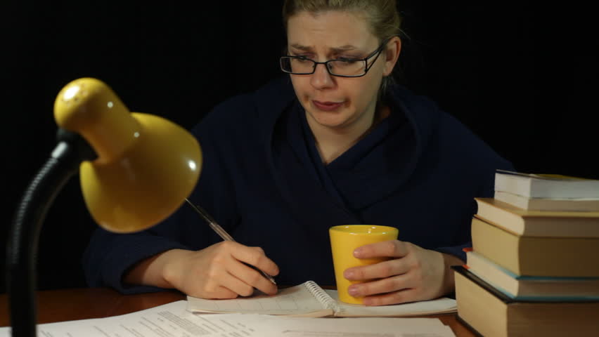 Tired overworked woman in bathrobe working overtime in home office at night