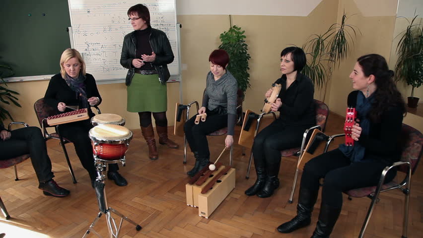 Right to left pan shot of the group of people that are learning a new song