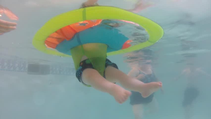 Underwater shot of a cute little baby boy at the swimming pool with his family.